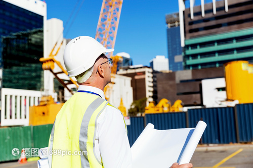 建筑工地的工程師建設(shè)者工程師建筑工人施工場景穿著帶藍(lán)圖的安全背心